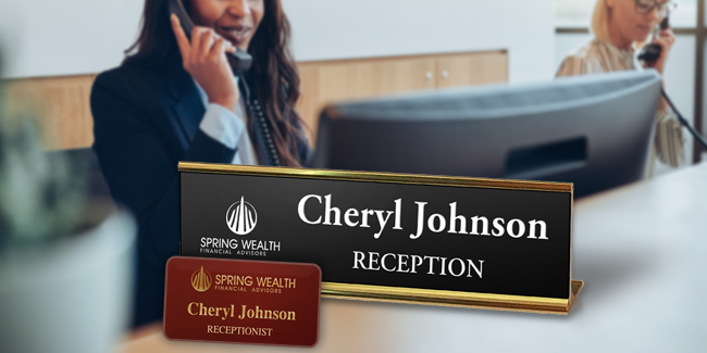 Matching logos on an engraved name tag and name plate with a concierge desk and workers in the background that expresses The Functionality of Name Plates In The Work Place.