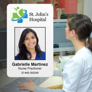 Nurse practitioner working on a computer with a photo ID badge.